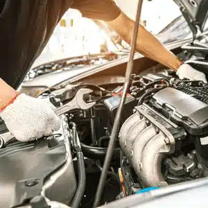 Mechanic fixing engine after noticing bmw warning signs related to leaks and low oil pressure