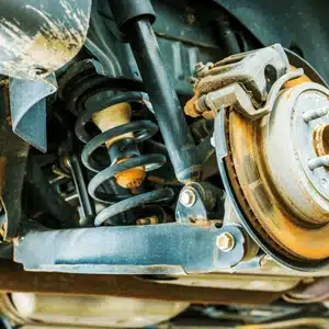 Detailed view showing rusted land rover suspension components including coil spring and shock absorber