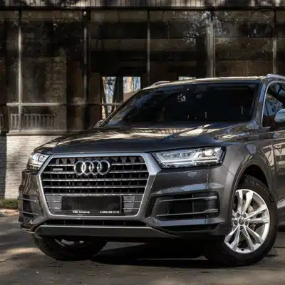 A parked Audi SUV in daylight, showcasing its sleek exterior and modern front grille