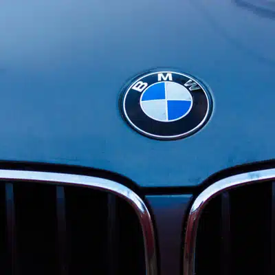 Close-up of BMW car emblem on hood, showcasing the iconic logo and front grille design