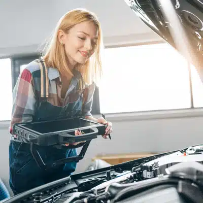 Technician uses tablet scanner under hood, performing vw diagnostics and troubleshooting engine performance issues today
