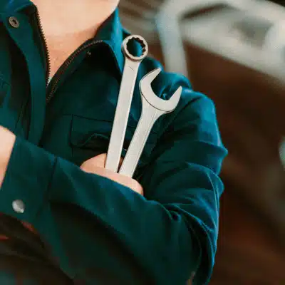 Auto technician holds wrenches confidently, ready for maintenance and quick euro auto repair services today